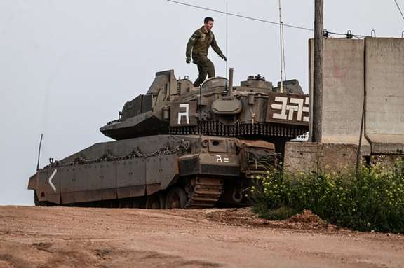 An Israeli soldier walks on top of a tank near Shtula, by the Israel Lebanon border, in northern Israel April 6, 2023.