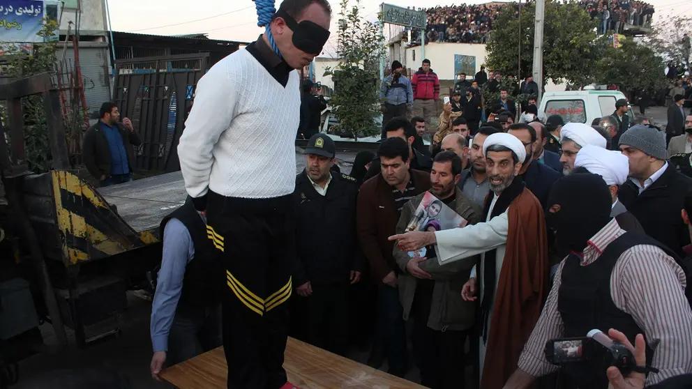 A blindfolded man stands on a platform moments before his public execution in Iran