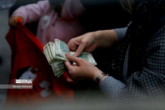 An Iranian woman counting rial banknotes in Tehran