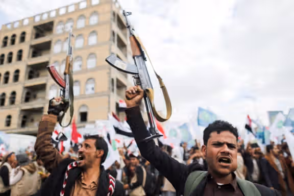 Supporters of Yemen's Houthis hold up their rifles as they rally to celebrate the seventh anniversary of the ousting of the government in Sanaa, 2021.
