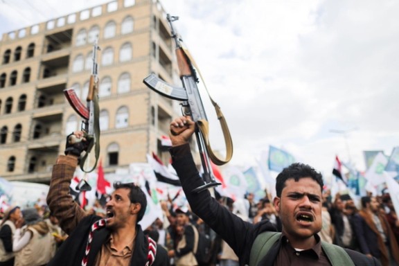Supporters of Yemen's Houthis hold up their rifles as they rally to celebrate the seventh anniversary of the ousting of the government in Sanaa, 2021.