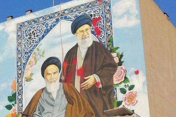 Red paint splashed on a large mural of Khomeni and Khamenei to symbolize regime bloodshed