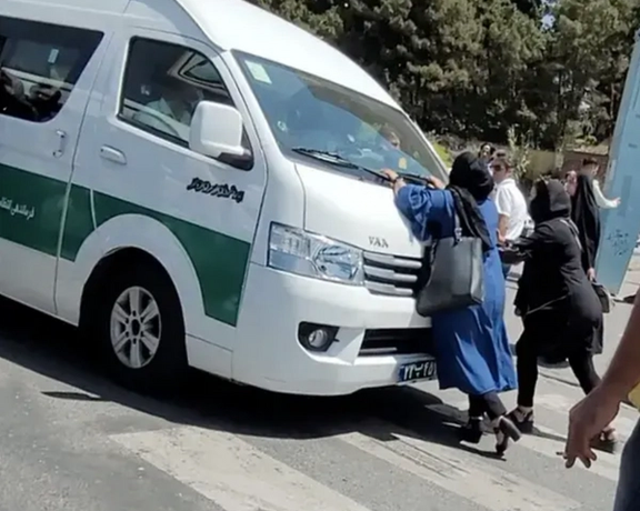 A mother trying to stop a police van that arrested her daughter for hijab