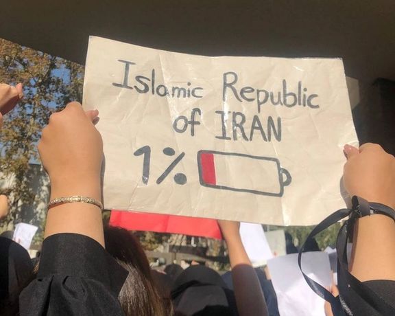 A student holding a sign in a Tehran university showing the Islamic Republic becoming weaker