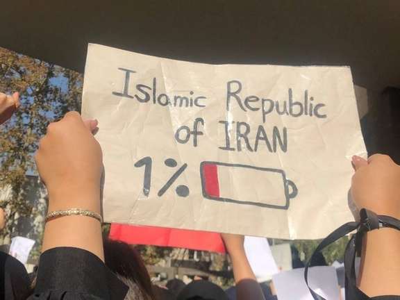 A student holding up a placard during a protests in Tehran University in November 2022