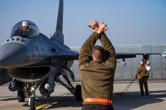 A US Air Force airman marshals an F-16 Fighting Falcon aircraft assigned to the 480th Fighter Squadron, at the 86th Air Base near Fetesti, Romania, February 17, 2022.