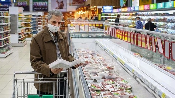 An Iranian man looking at the prices of case-ready meat in a department store