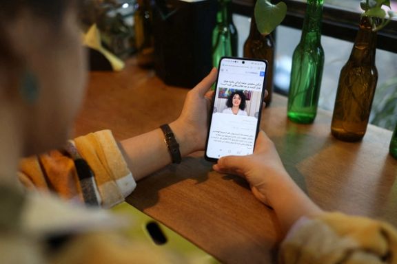 An Iranian woman sees the news of Iranian activist Narges Mohammadi winning the Nobel Peace Prize on her mobile phone, in a cafe in Tehran, Iran, October 6, 2023.