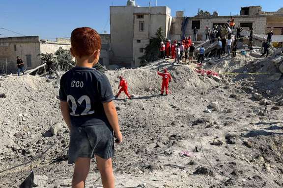 A child stands next to the rubble of a building damaged in an Israeli strike in Qennarit, southern Lebanon, June 20, 2026.