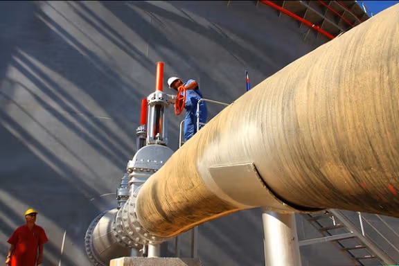 Workers service oil industry infrastructure in Iran