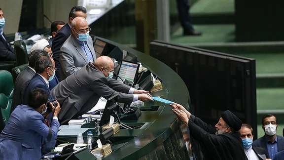 Iran's President Ebrahim Raisi Handing the new budget to Parliament Speaker Ghalibaf on December 12.