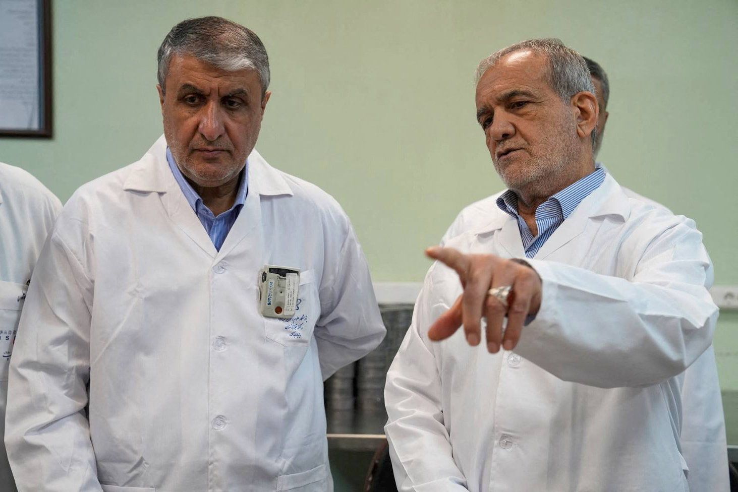 Iranian President Masoud Pezeshkian speaks with Mohammad Eslami, Head of the Iranian Atomic Energy Organisation, in Tehran, Iran, November 2, 2025.