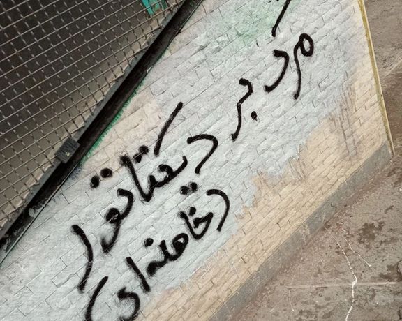 A slogan written on a wall says, "Death to the dictator, Khamenei"