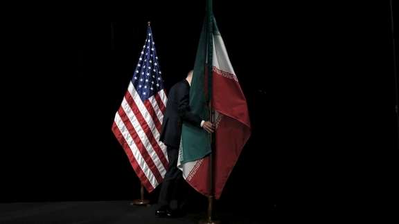 A staff member removes the Iranian flag from the stage after a group picture with foreign ministers and representatives of the U.S., Iran, China, Russia, Britain, Germany, France and the European Union during the Iran nuclear talks at the Vienna International Center in Vienna, Austria July 14, 2015.