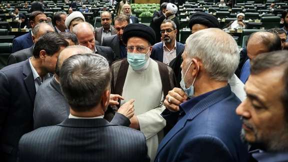 Iranian President Ebrahim Raisi among a group of lawmakers at the parliament