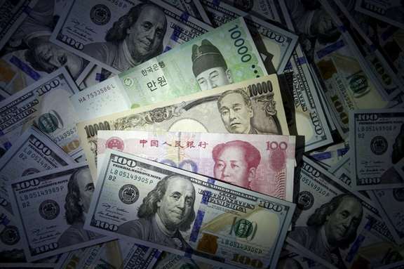 South Korean won, Chinese yuan and Japanese yen notes are seen on US 100 dollar notes in this file photo illustration shot December 15, 2015.