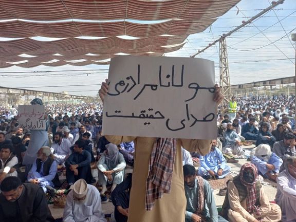 A young man holding a placard in support of prominent Sunni cleric Mowlavi Abdolhamid during Friday prayers in Zahedan