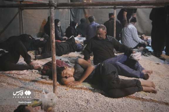 People sleeping on the ground in camps on their way to the Iraqi city of Karbala