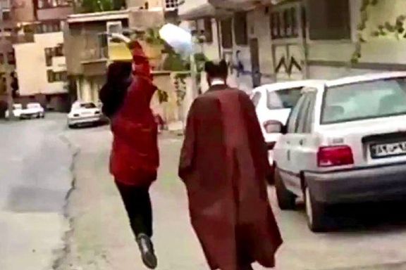 A girl flipping the turban of a cleric in Iran