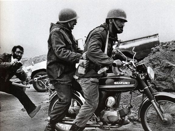 Banisadr at the back of a motorbike in the front during the Iran-Iraq war. Undated.