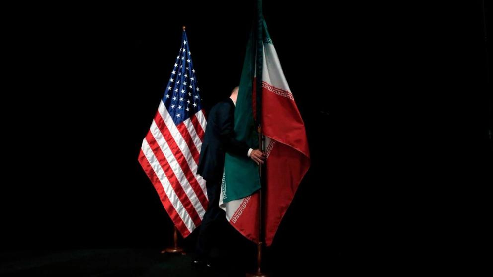 A staffer removing the Iranian flag from the stage after a group picture of officials participating the Iran nuclear talks at Austria International Centre in Vienna, Austria on July 14, 2015