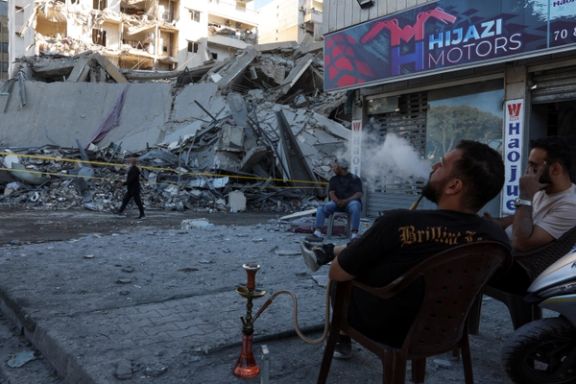 A man smokes a shisha, near a damaged site, in the aftermath of Israeli airstrikes on Sunday that hit several branches of a financial institution linked to Hezbollah in Beirut, October 21, 2024.