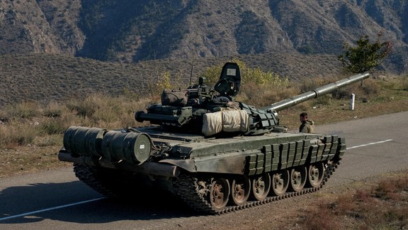 A service member of the Russian peacekeeping troops stands next to a tank near the border with Armenia, following the signing of a deal to end the military conflict between Azerbaijan and ethnic Armenian forces, in the region of Nagorno-Karabakh, November 10, 2020.