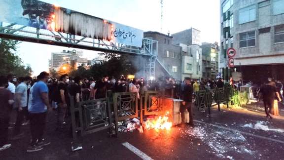 People light a fire during a protest in Tehran several days after the death of Mahsa Amini, September 21, 2022