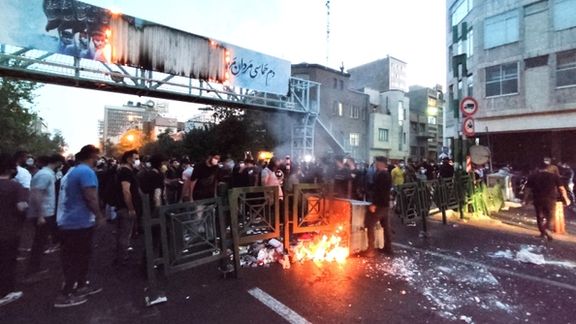 People light a fire during a protest in Tehran several days after the death of Mahsa Amini, September 21, 2022