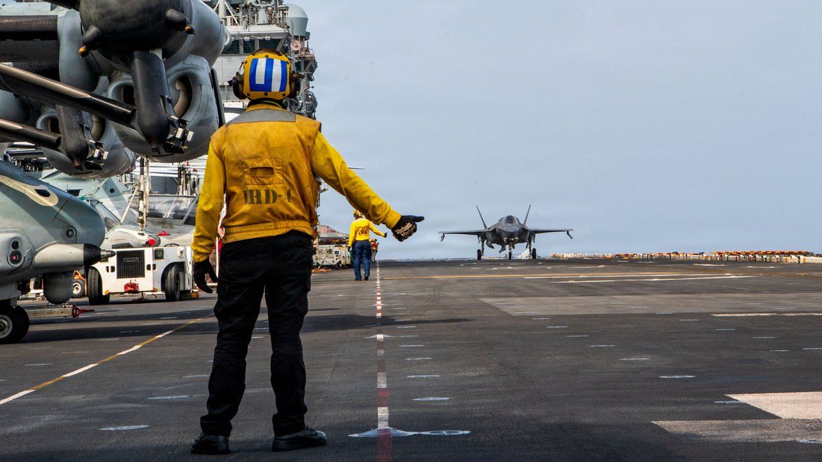 A US sailor directs an F-35B fighter jet on the flight deck of the USS Boxer (CENTCOM/X).