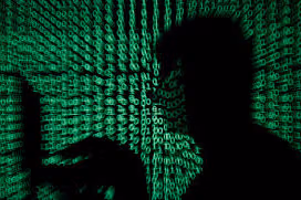 A man holds a laptop computer as cyber code is projected on him, File Photo.