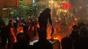 An undated photo showing protesters lighting a fire in the street and burning veils