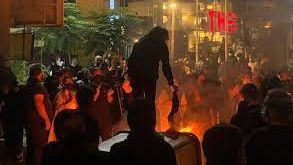 An undated photo showing protesters lighting a fire in the street and burning veils