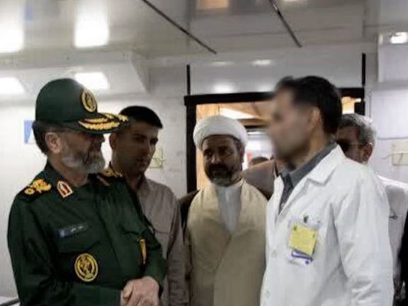 Iranian military and clerical officials visit a hospital ward, speaking with medical staff.