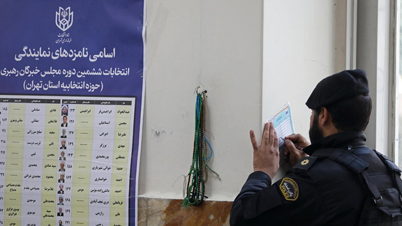 A uniformed officer writing in his ballot on March 1, 2024