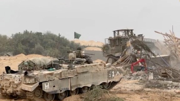 An Israel Defense Forces (IDF) armored vehicle waits as an armored bulldozer clears a debris-strewn path in a location given as Gaza. Octo. 29, 2023