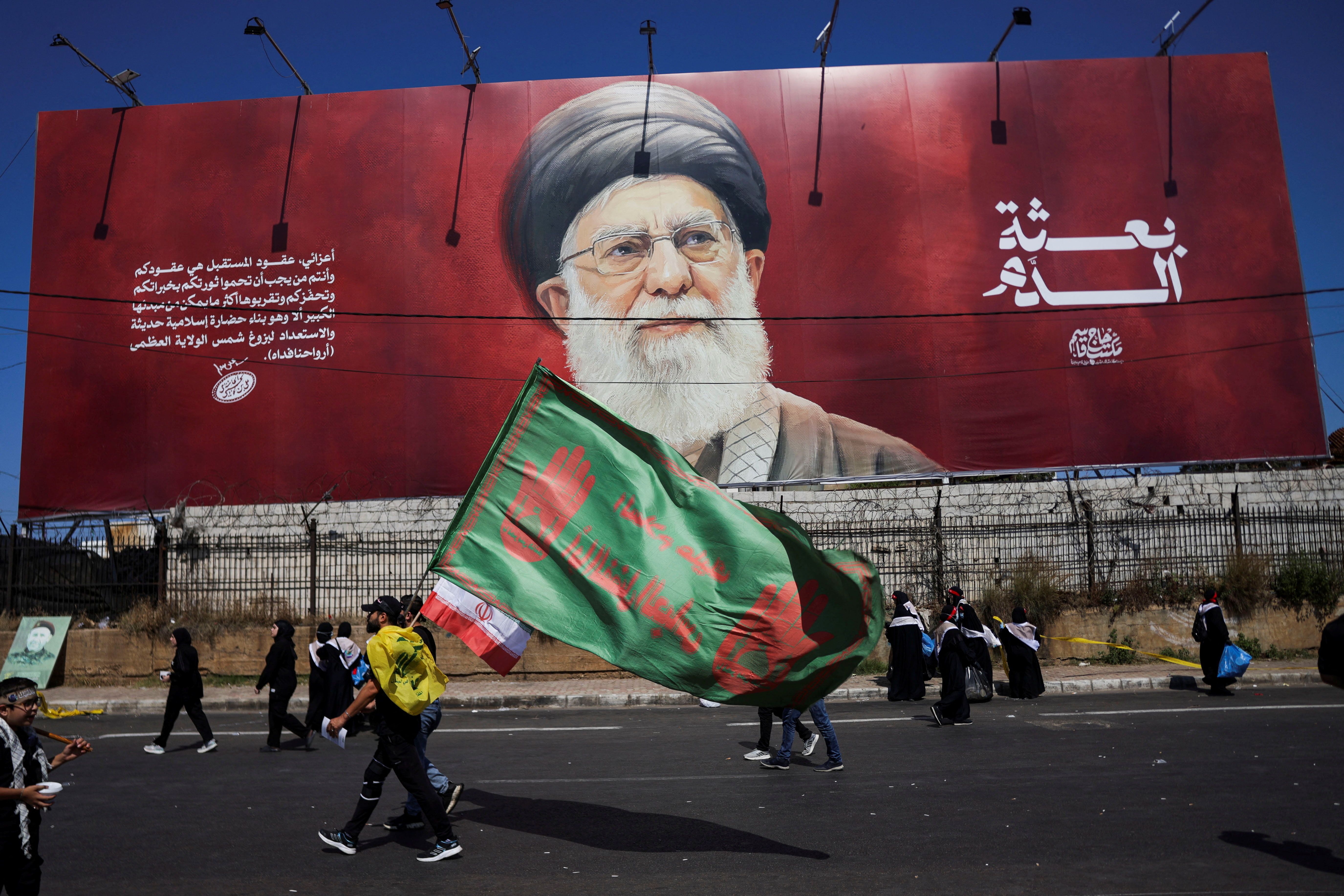 Shiite mourners walk past a banner depicting Iran's late Supreme leader Ali Khamenei as they mark Ashura, the holiest day on the Shiite Muslim calendar, in the southern suburbs of Beirut, Lebanon, June 26, 2026. 