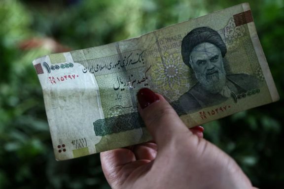 A woman holds an Iranian currency in Tajrish Bazaar in Tehran, Iran August 1, 2019.