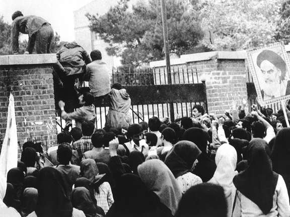 Iranian students climbing up US embassy gates in Tehran in 1979