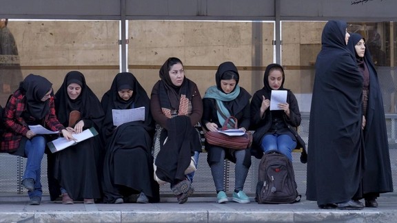 Iranian students study as they wait for a bus in central Tehran January 16, 2016