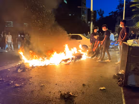 A police motorcycle burns during a protest over the death of Mahsa Amini, a woman who died after being arrested by the Islamic republic's "morality police", in Tehran, Iran September 19, 2022