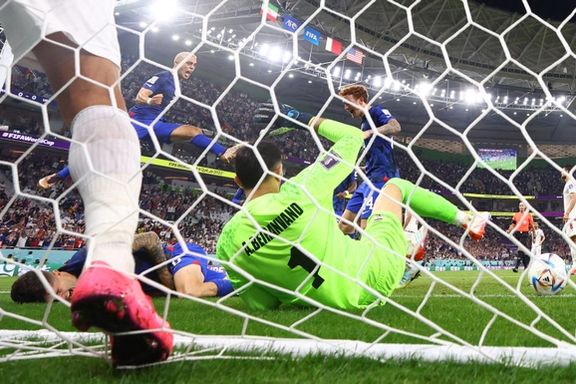 Christian Pulisic of the US after he scores their first goal and collides with Iran's goalie Alireza Beiranvand