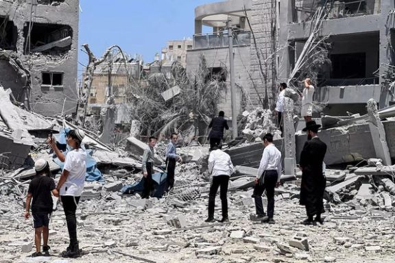 یهودیان ارتدکس در محل اصابت موشک پس از حمله موشکی جمهوری اسلامی به اسرائیل، در بنیبراک حضور دارند. اسرائیل؛ ۱۶ ژوئن ۲۰۲۵.