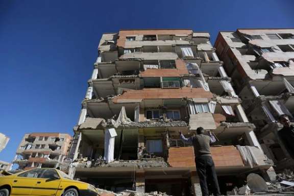 A man reacts as he looks at a damaged building in Sarpol-e Zahab county in Kermanshah, Iran. (November 2017)