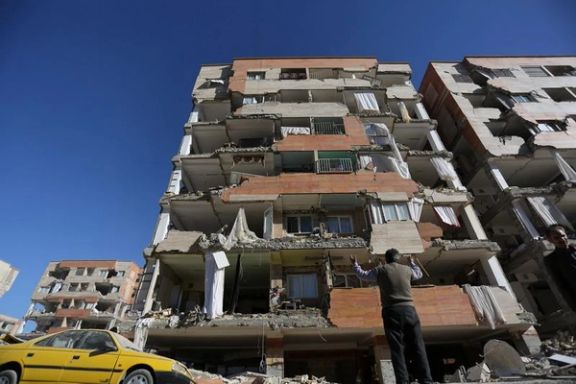 A man reacts as he looks at a damaged building in Sarpol-e Zahab county in Kermanshah, Iran. (November 2017)