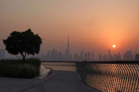 The Burj Khalifa building peaks through the skyline as the sun sets over Dubai, United Arab Emirates, September 9, 2023.