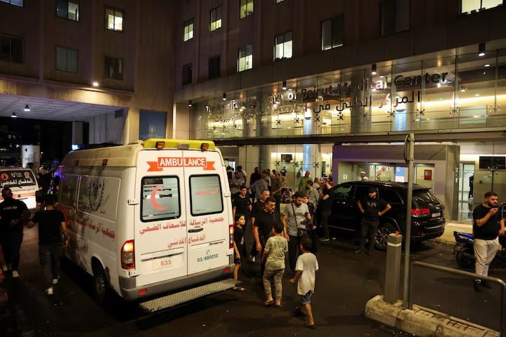 People walk near an ambulance outside American University of Beirut Medical Center (AUBMC) as people, including Hezbollah fighters and medics, were wounded and killed when the pagers they use to communicate exploded across Lebanon, according to a security source, in Beirut, Lebanon September 17, 2024.