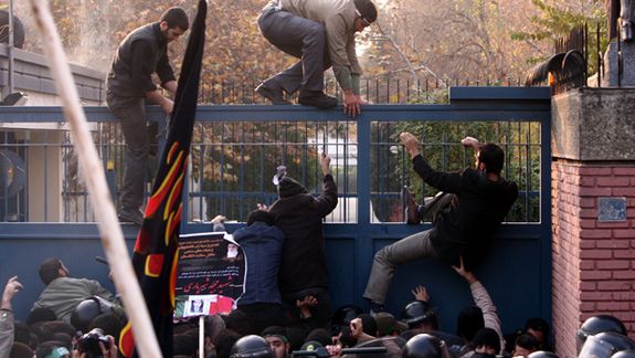 Ultra-hardliner protesters climbing over the gate of the UK Embassy in Tehran in November 2011