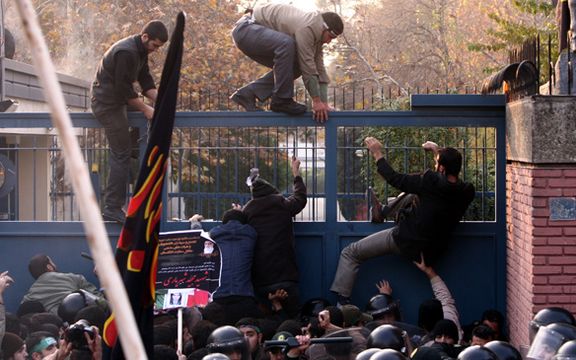 Ultra-hardliner protesters climbing over the gate of the UK Embassy in Tehran in November 2011