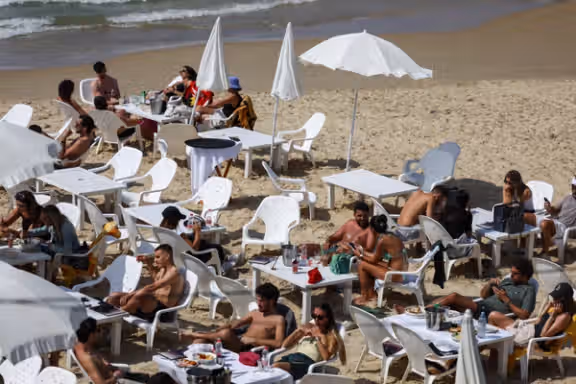People rest on the beach, after Iran launched drones and missiles towards Israel, in Tel Aviv, Israel, April 14, 2024.